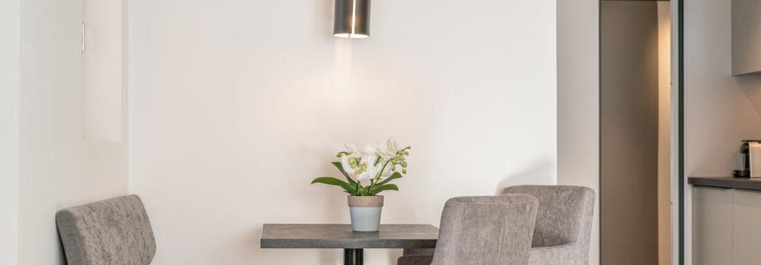 Appartement Edelweiss | © Pension Miramonte (CC C) A bright room with a small table and two chairs. On the table, there is a flower pot with white flowers. - Pension Miramonte - Sölden