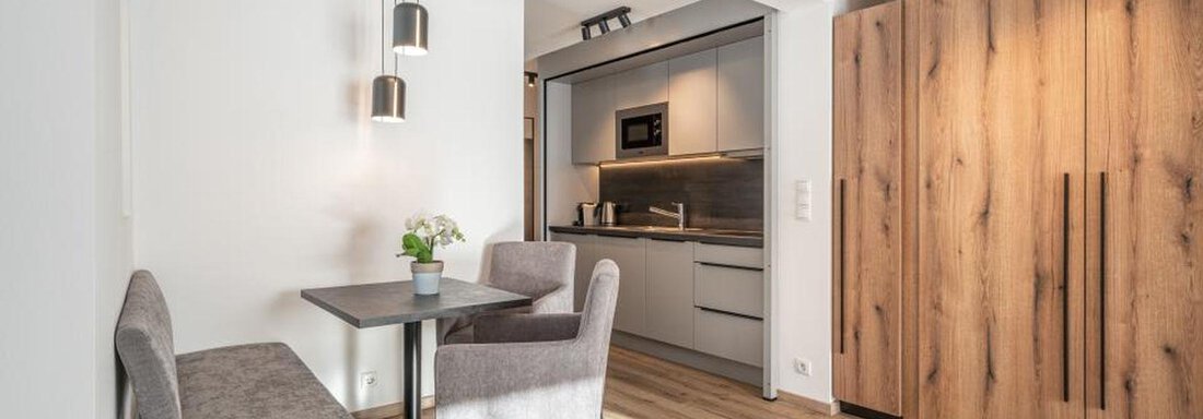 A modern residential kitchen with a dining area and a bright wooden paneling. The room is designed to be friendly and cozy. - Pension Miramonte - Sölden