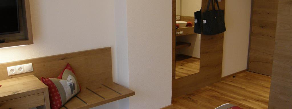 A cozy hotel room with wooden furniture and a television. The room has a pleasant atmosphere and a modern style. - Pension Sportalm - Sölden