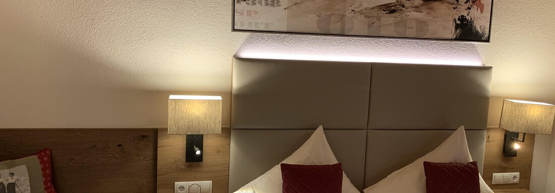 A cozy bedroom with two beds and modern lamps. A beautiful piece of art hangs on the wall, creating a relaxing atmosphere. - Pension Sportalm - Sölden