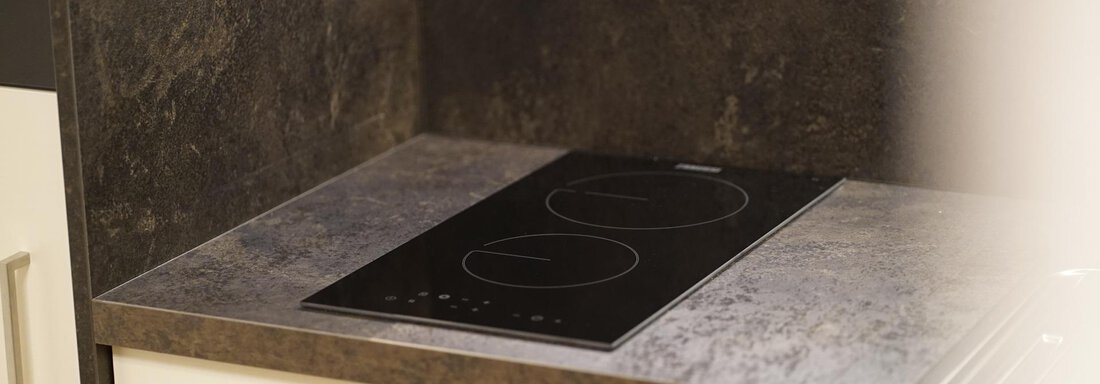 A modern cooktop plate in a stylish kitchen. The surface is made of gray material and looks elegant. - Pension "Zur alten Mühle" - Sölden