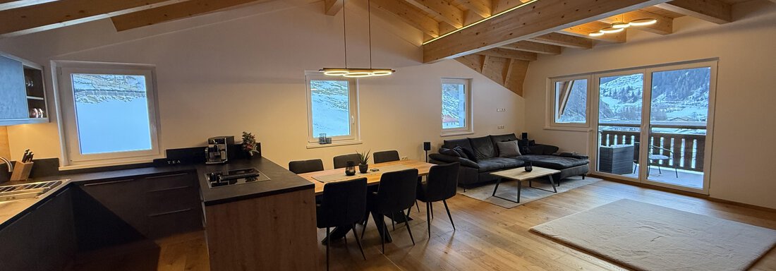 IMG_6194 Modern apartment with wooden beam ceiling and large living area.
Bright design with kitchen, dining table, and cozy couch. - Pension "Zur alten Mühle" - Sölden
