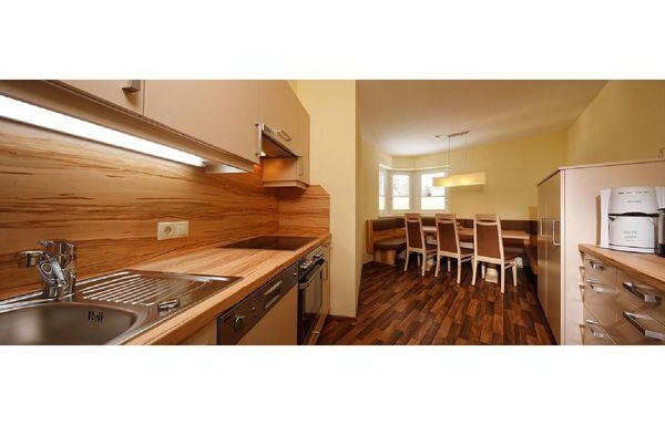A modern kitchen with wooden surfaces and a spacious dining area. Bright walls and a pleasant ambiance create an inviting atmosphere. - Residenz Allegra - Sölden