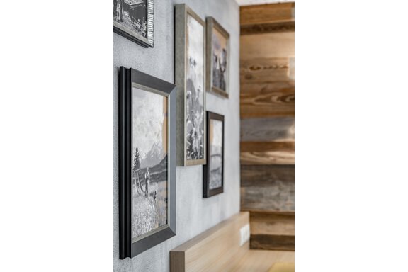 A modern room with appealing black-and-white photographs framed on the wall. The decor is simple and stylish, with a wooden floor in the background. - Residenz Allegra - Sölden
