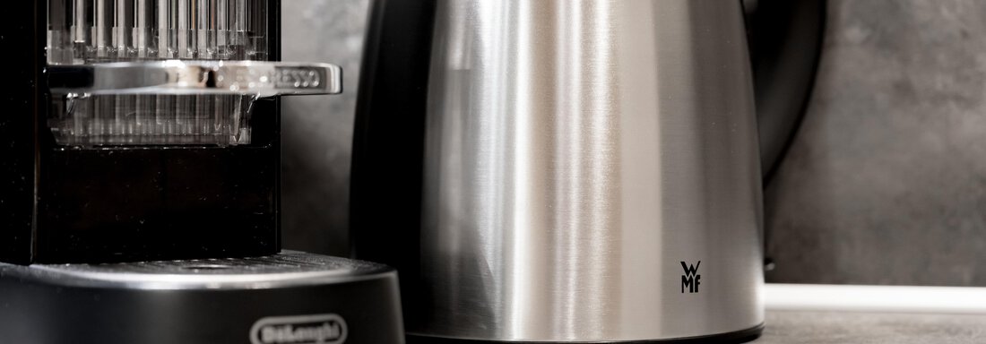 A modern stainless steel kettle stands next to a coffee maker. The combination complements an elegant kitchen decor. - Residenz Allegra - Sölden