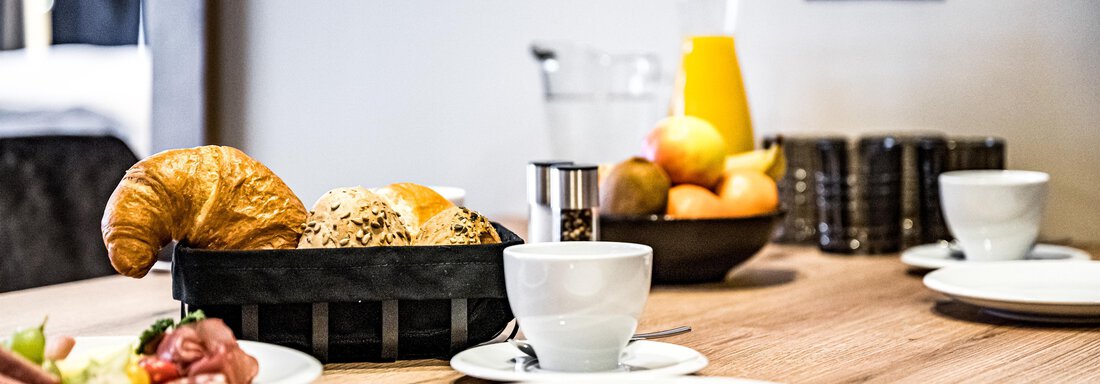 A beautiful breakfast table with fresh rolls, fruit, and coffee. The table radiates coziness and a pleasant atmosphere. - Sonnalp Residences - Sölden