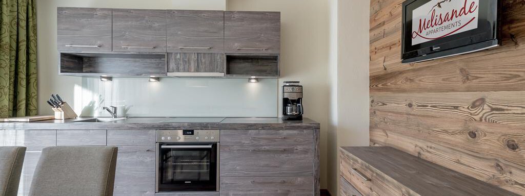 A modern kitchen with wooden shelves and stainless steel appliances. The room is designed to be bright and inviting. - The Peak Sölden - Sölden