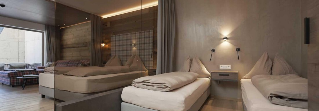 A modern hotel room with two single beds and minimalist design. Large windows provide plenty of natural light and a pleasant atmosphere. - The Peak Sölden - Sölden