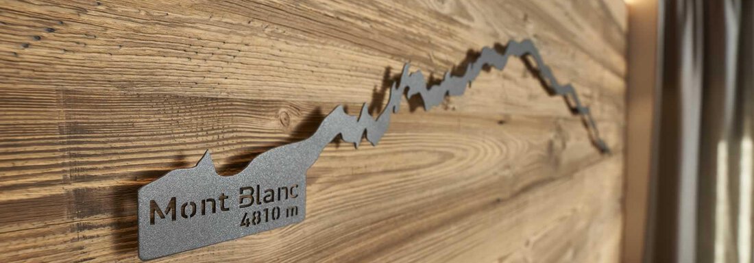 A decorative wooden wall with a metal graphic of Mont Blanc. Next to it is "Mont Blanc 4810 m" in elegant script. - The Peak Sölden - Sölden