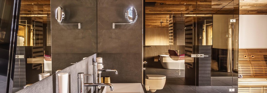 A modern bathroom with a wooden ceiling and elegant fixtures. The space features a clean, minimalist design and high-quality materials. - The Peak Sölden - Sölden