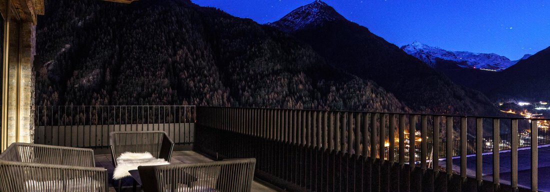 A cozy balcony with modern furniture, surrounded by mountains. The sky is clear and at night sprinkled with many stars. - The Peak Sölden - Sölden