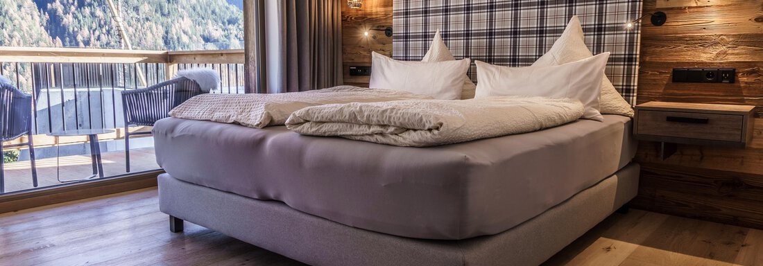 Mont Blanc (6) A cozy bedroom with a large bed and wooden paneling. Through the windows, you can see mountains and a beautiful view. - The Peak Sölden - Sölden