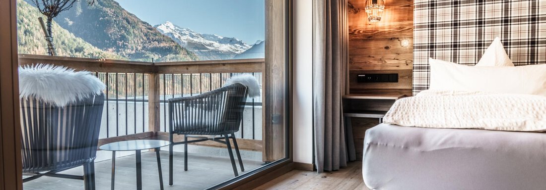 A modern room with a panoramic balcony and a view of the mountains. The bright decor and wooden elements create a cozy atmosphere. - The Peak Sölden - Sölden