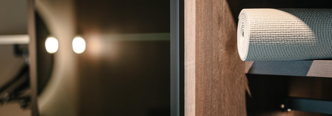 A modern piece of furniture with a wooden surface and a decorative roll. Soft light illuminates the structure and creates a relaxed atmosphere. - VIBES Sölden - your alpine homebase - Sölden
