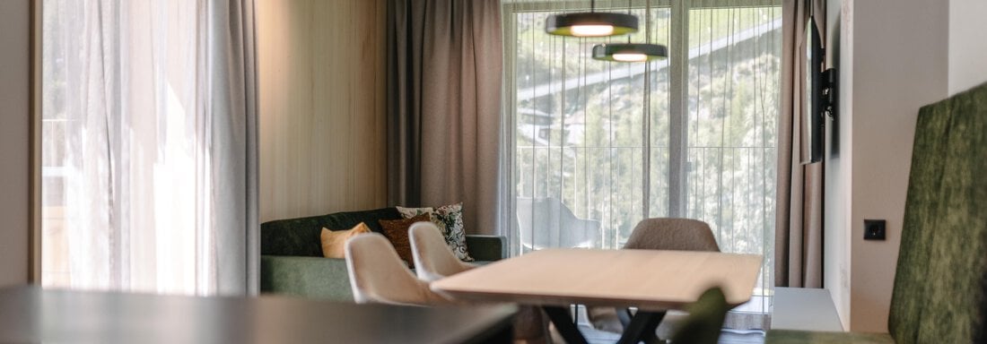 APP I_Wohnzimmer_1 A modern living room with a bright color scheme. Large windows and stylish furniture create an inviting atmosphere. - VIBES Sölden - your alpine homebase - Sölden