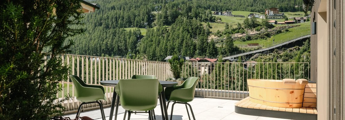 A cozy terrace overlooking green hills and mountains. Seating invites you to relax. - VIBES Sölden - your alpine homebase - Sölden