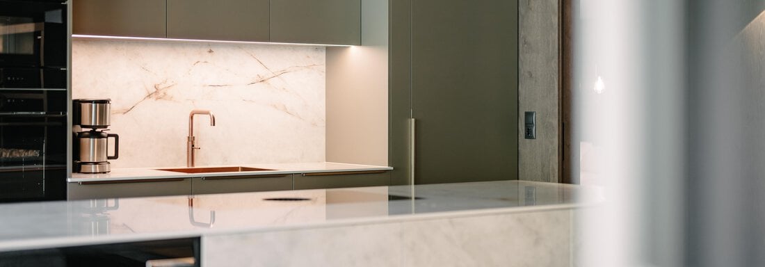 Modern kitchen with elegant stone surface and subtle lighting. Coffee machine and sink are prominently visible. - VIBES Sölden - your alpine homebase - Sölden
