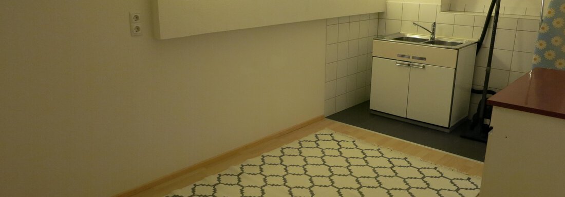 A bright room with a simple, modern design. In one corner, there is a small kitchenette with a table and chairs. - Apart Martina - Umhausen