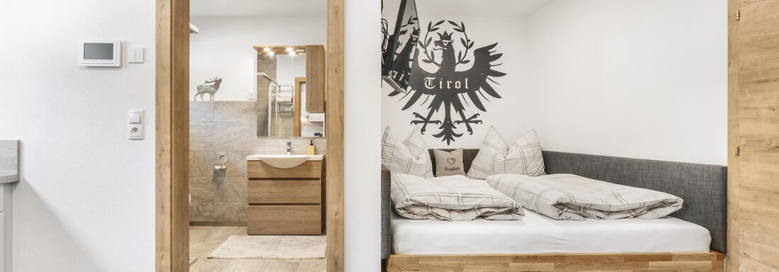 Bett und Eingang Badezimmer - Appart 69 - Umhausen