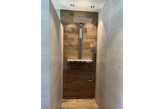 Eine moderne Dusche mit einer Holzverkleidung und hochwertigen Armaturen. Die Wände sind in hellen Farben gehalten und schaffen eine entspannende Atmosphäre. - BLANKA'S Apart Auszeit - Umhausen