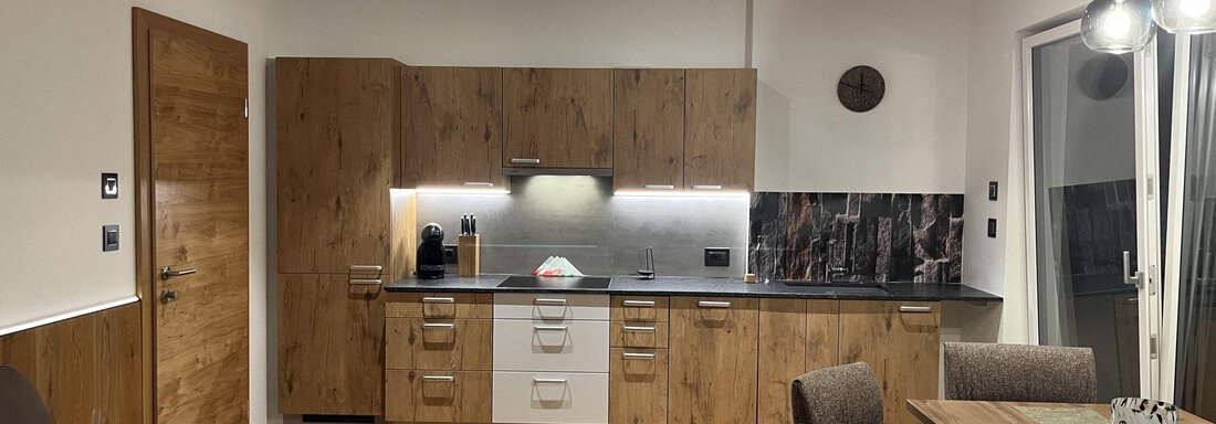 Eine moderne Küche mit Holz- und Metallakzenten. Der Raum ist hell und lädt zum Kochen und Verweilen ein. - BLANKA'S Apart Auszeit - Umhausen
