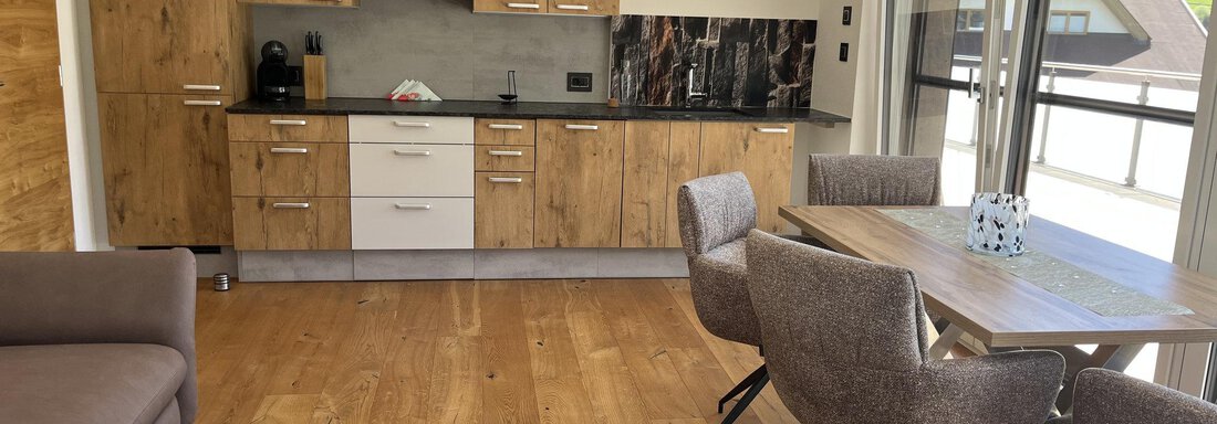 Moderne Küche mit Holzschränken und eleganter Essbereich. Heller Raum mit großen Fenstern und Holzfußboden. - BLANKA'S Apart Auszeit - Umhausen