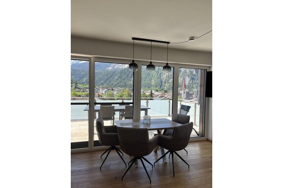 Ein moderner Essbereich mit einem Tisch und Stühlen. Durch große Fenster ist ein schöner Ausblick auf die Berge und die Landschaft sichtbar. - BLANKA'S Apart Auszeit - Umhausen