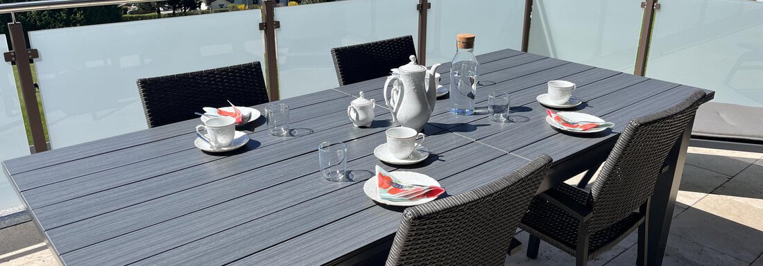 Ein schöner Esstisch auf einer Terrasse mit Blick auf die Berge. Die Tafel ist mit Geschirr und Gläsern gedeckt, bereit für eine Mahlzeit im Freien. - BLANKA'S Apart Auszeit - Umhausen