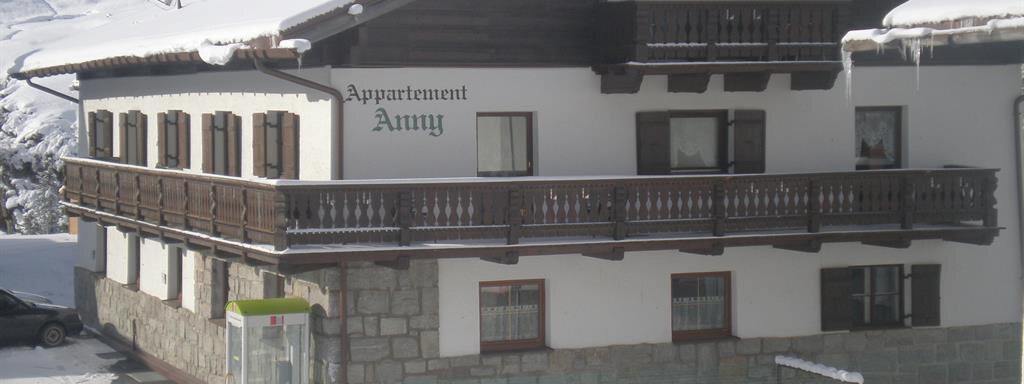 Winter 1 A cozy chalet in the snow called "Appartement Anny" on the facade. Surrounded by snow-covered mountains and a serene winter landscape. - Appt. Garni Anny - Vent