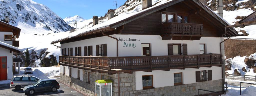 A traditional chalet in the snow named "Appartement Ammy". The surroundings feature tall mountains and a clear blue sky. - Appt. Garni Anny - Vent
