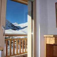 A beautiful view of snow-covered mountains from a balcony. The window lets in plenty of daylight. - Gästehaus Soldanella - Vent
