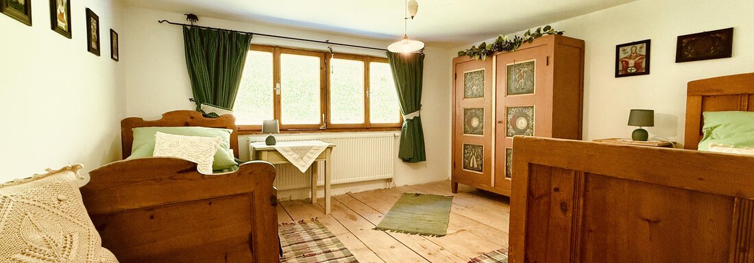 A cozy room with wooden floors and rustic furniture.  
Two beds and a wardrobe provide an inviting atmosphere. - Haus Freistabl - Vent
