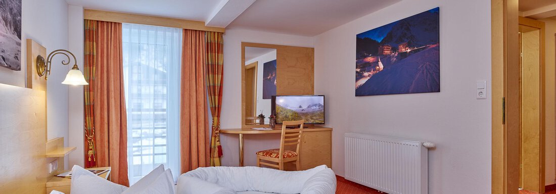 A cozy hotel room with two beds and a desk. Bright colors and a window create a pleasant atmosphere. - Hotel Vent - Vent