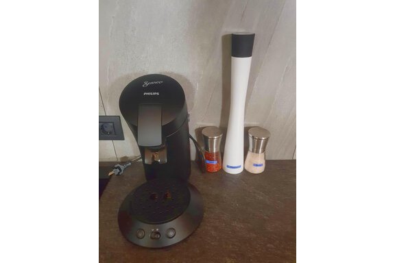 A coffee machine is on a dark countertop. Next to it are two spice containers. - Haus Fortuna - Zwieselstein
