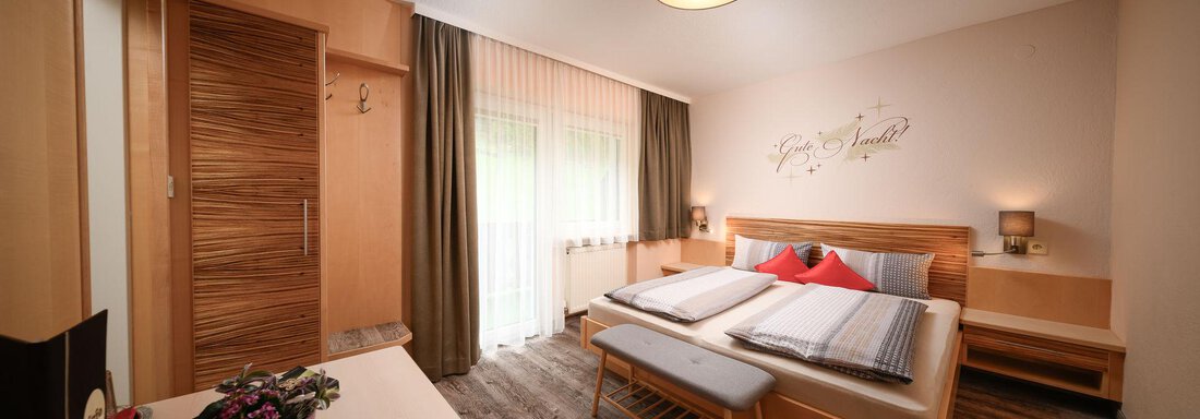 Doppelzimmer 03 Standard A cozy hotel room with a double bed and clear colors. Large windows let in plenty of daylight and create an inviting atmosphere. - Haus Sonnschein - Zwieselstein