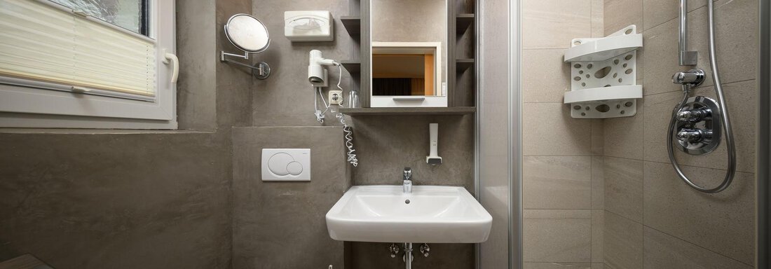 A modern bathroom with shower, sink, and toilet. The furnishings are designed to be bright and functional. - Haus Sonnschein - Zwieselstein