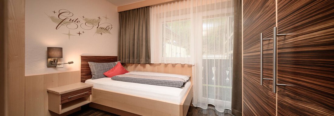 Einzelzimmer A modern bedroom with a single bed and hardwood floor. The room has large windows and a pleasant, bright atmosphere. - Haus Sonnschein - Zwieselstein