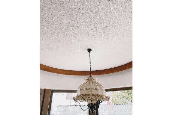 A view of a ceiling with a decorative lamp. The room has a bright atmosphere and simple wood paneling. - Landhaus Rosenhof - Zwieselstein