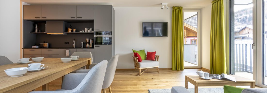 A modern apartment with an open kitchen and a cozy living area. Large windows provide plenty of daylight and an inviting atmosphere. - Zwieselstein-Apart De Luxe - Zwieselstein